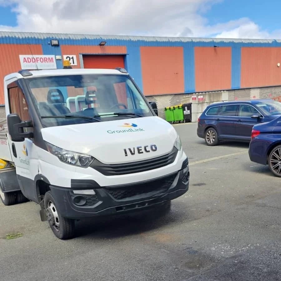 A white Iveco van in GroundLink livery parked in the yard outside the units.